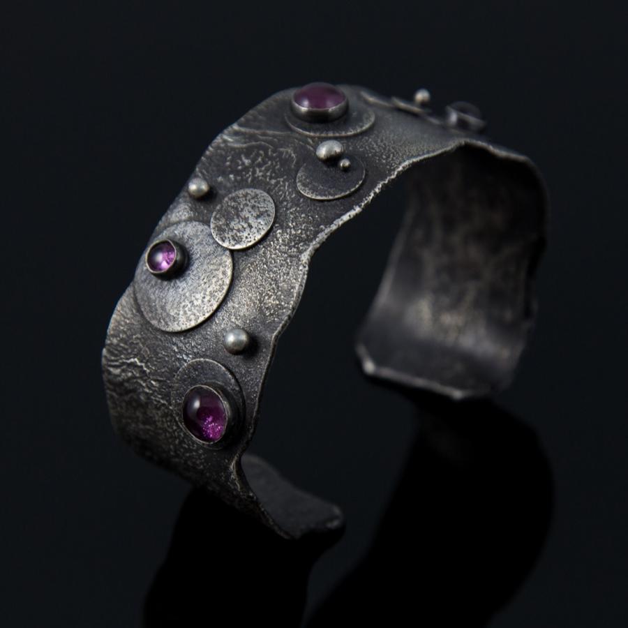 Silver cuff bracelet with pink stones, photograph.
