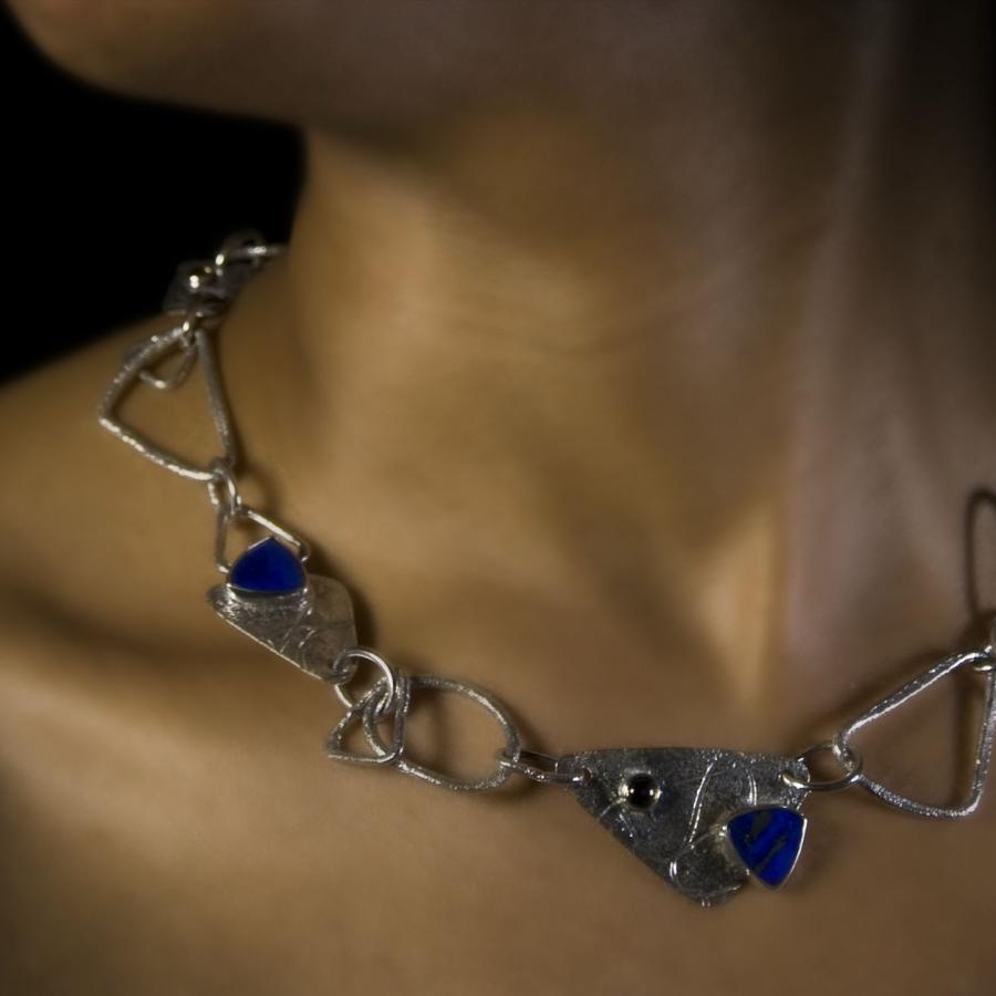 Close-up of woman wearing a silver and blue stone necklace.