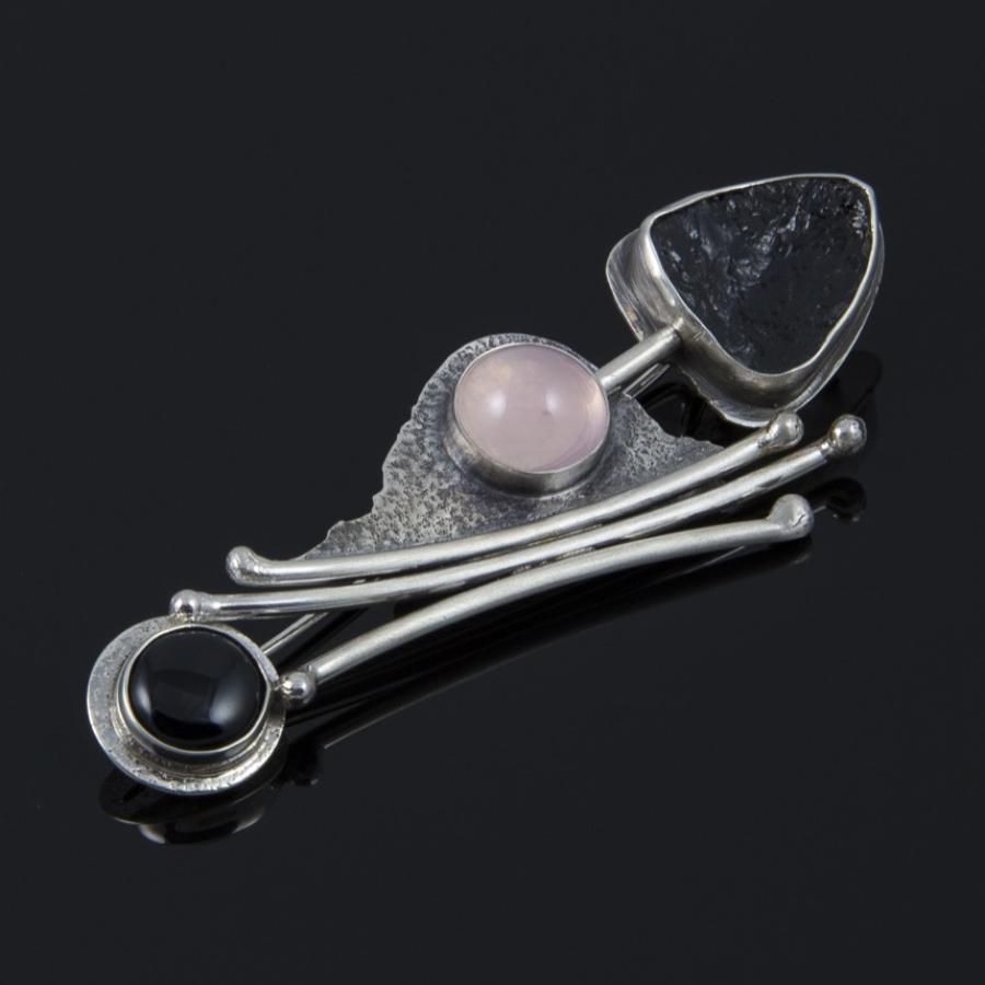 Unique silver brooch with black and pink stones.