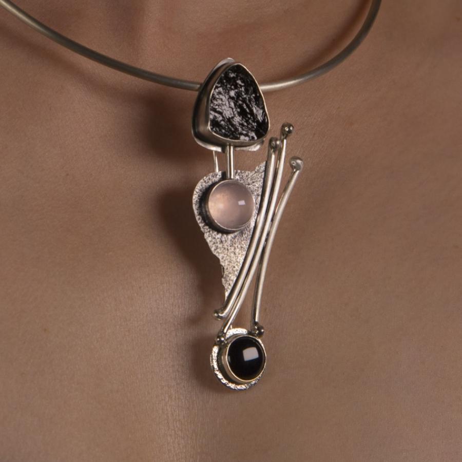 Necklace with stones on person's chest, close-up.