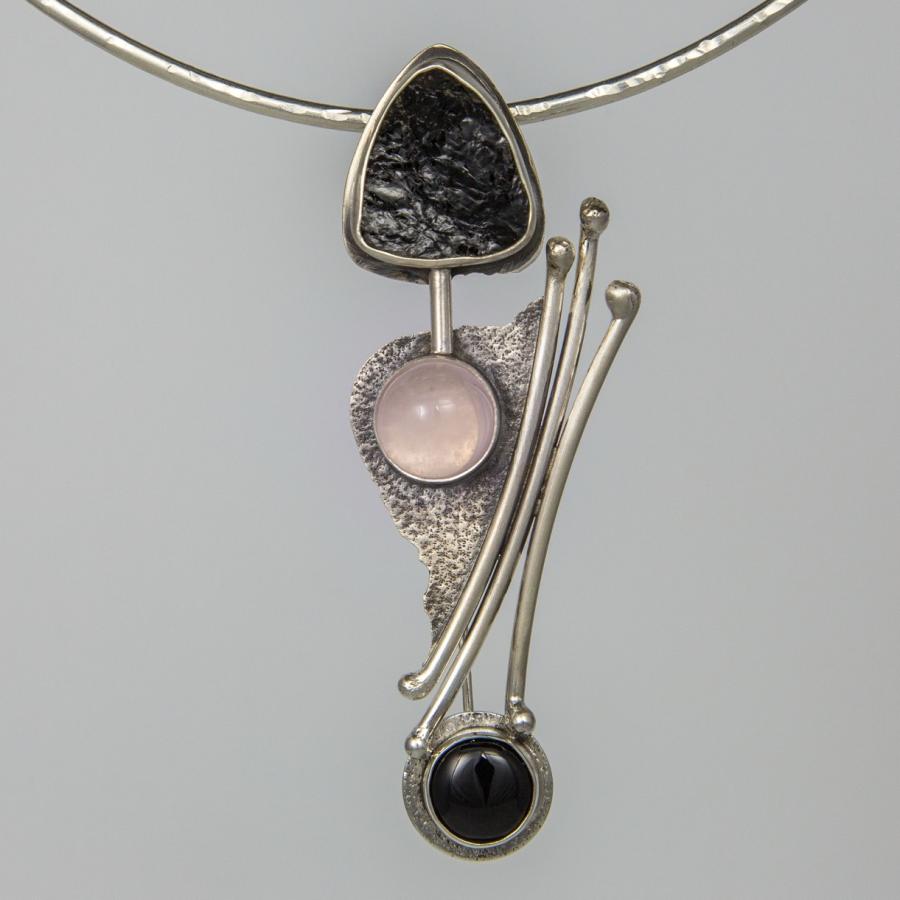 Silver necklace with black and pink stones.