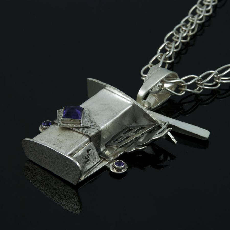 Silver pendant necklace on a black background.