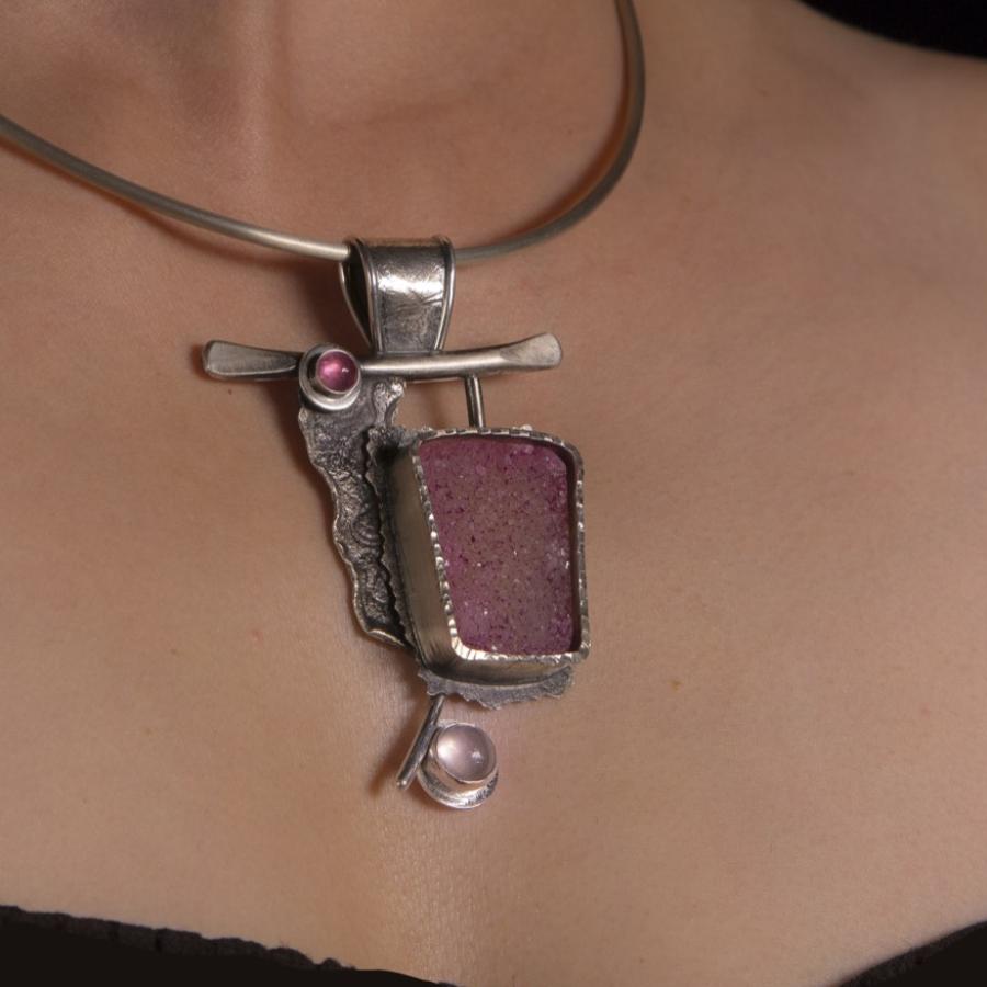 Necklace with pink stones on woman's chest.