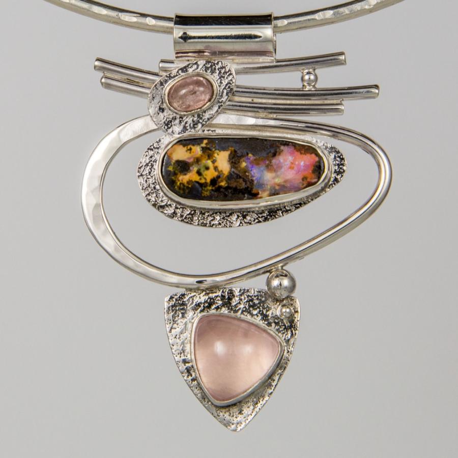 Silver necklace with opal and pink gemstone pendants.