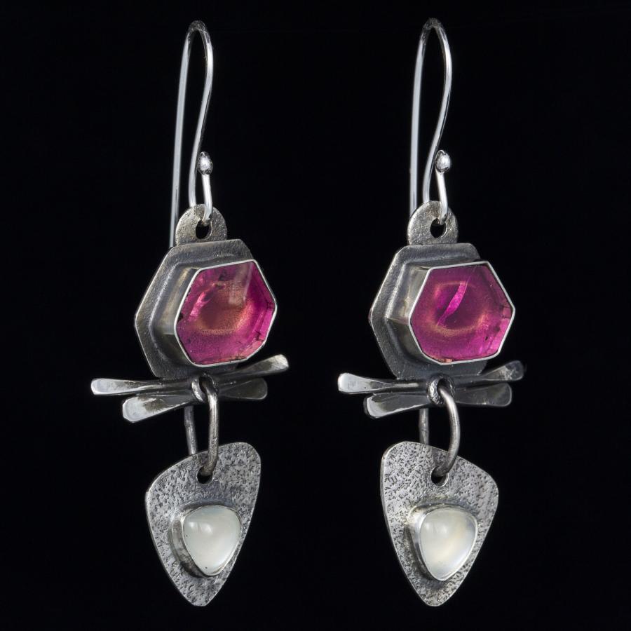 Two decorative silver earrings with pink stones.