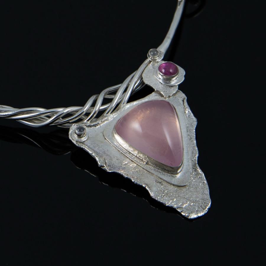 Silver necklace with a pink triangular stone.