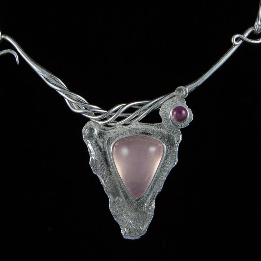 Silver necklace with pink pendant, photograph.
