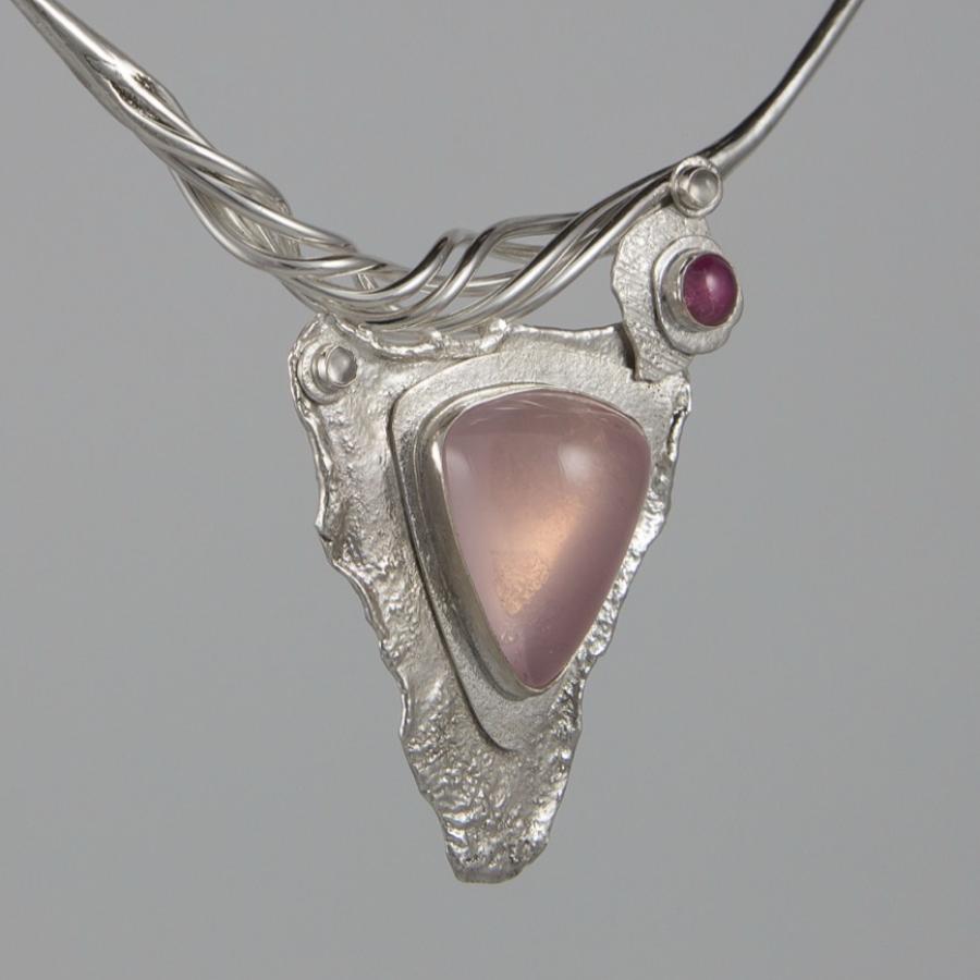 Necklace with triangular pink stone and silver setting.
