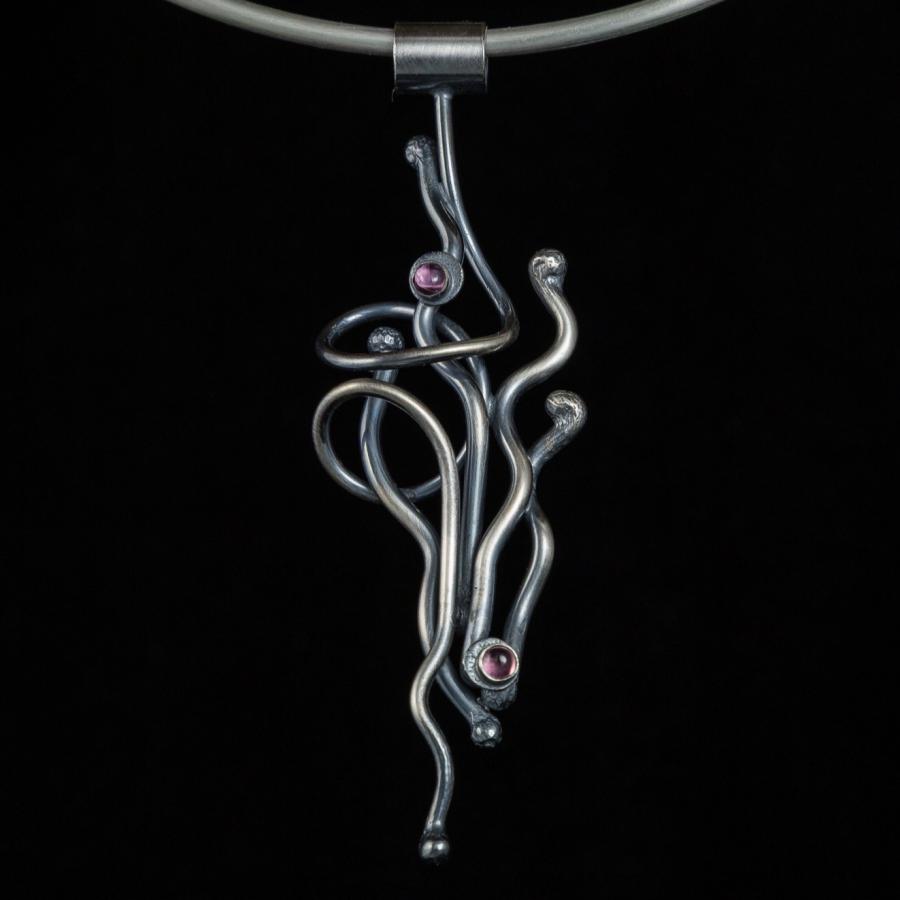 Artistic silver necklace with pink stones, photograph.