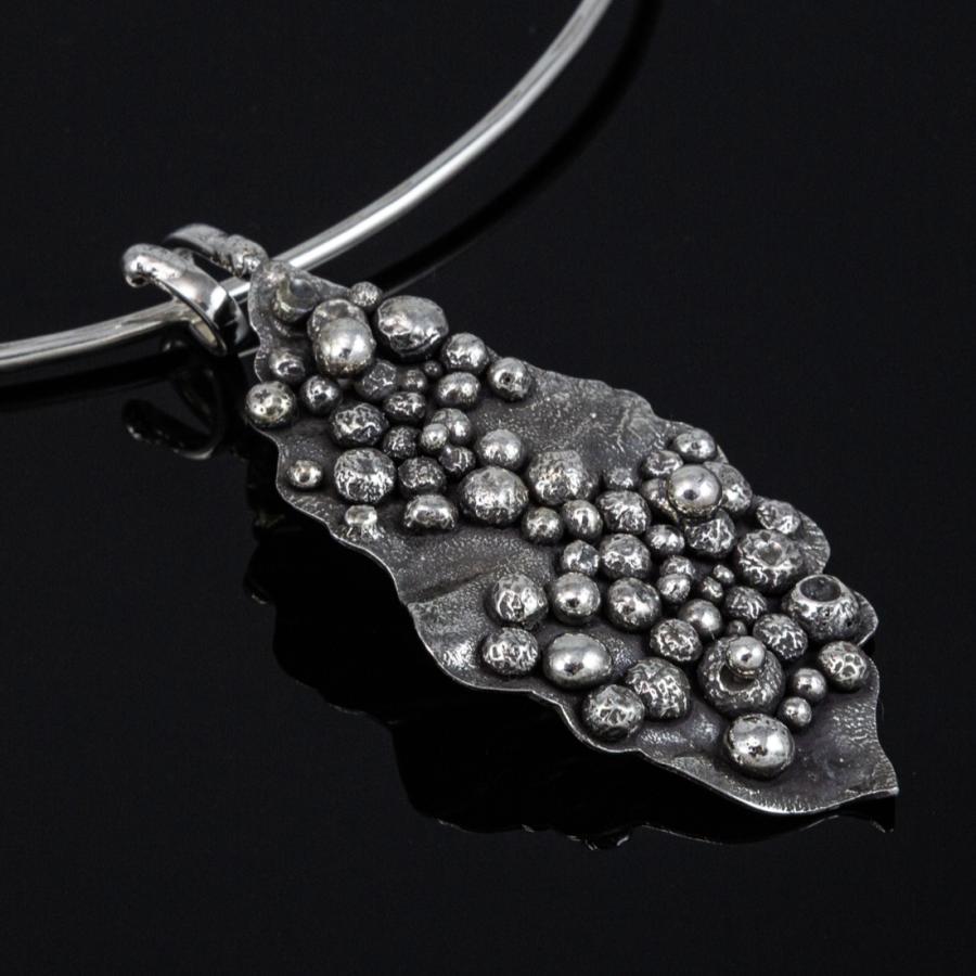 Silver pendant necklace, photograph.