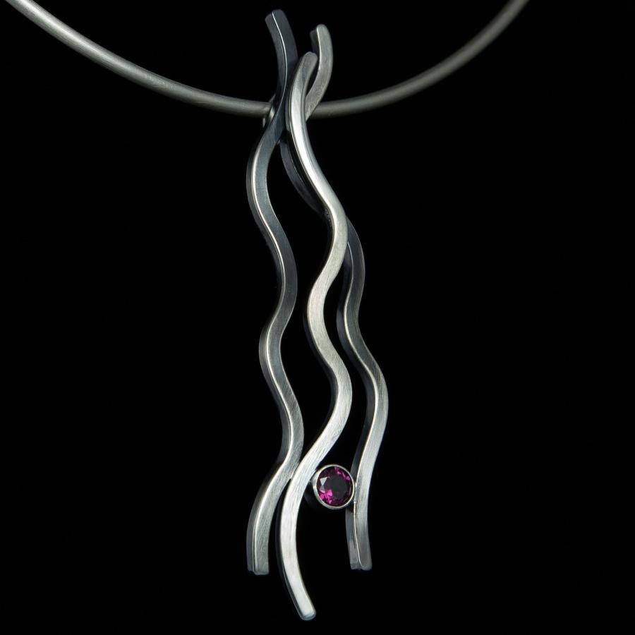 Silver pendant necklace with pink gem.