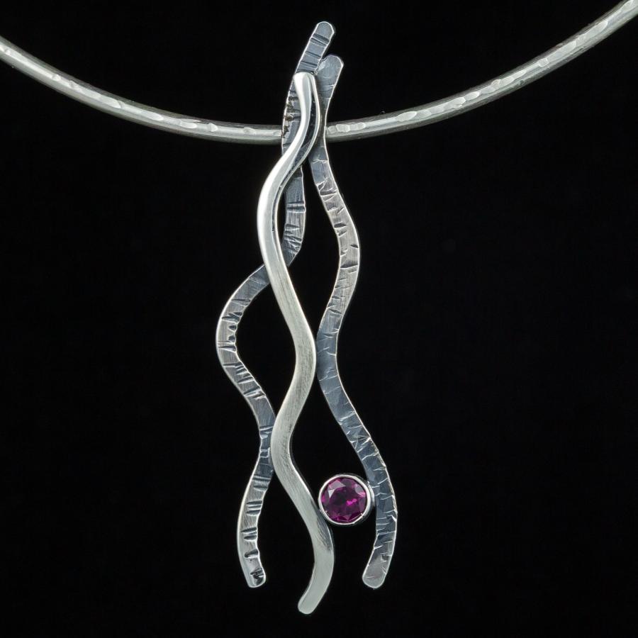 Silver pendant necklace with pink stone.