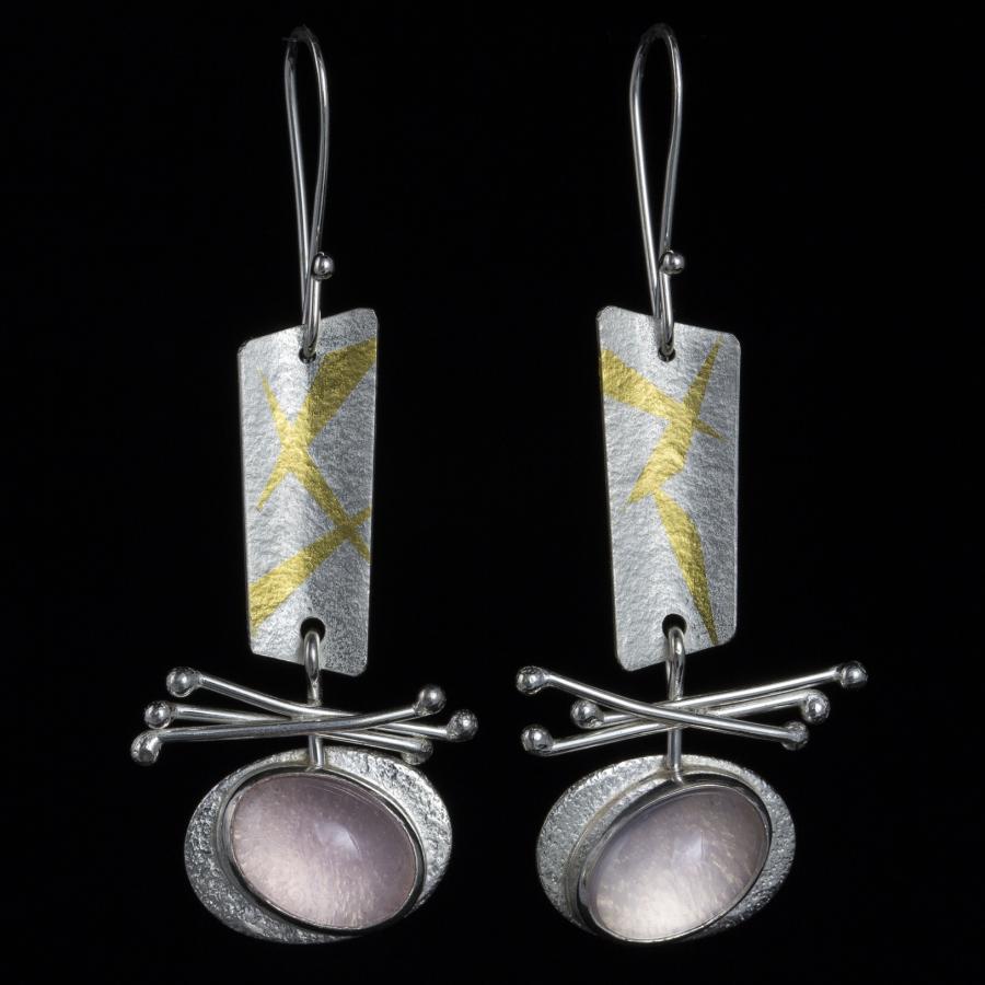 Photograph of silver and gold earrings with a pink stone.