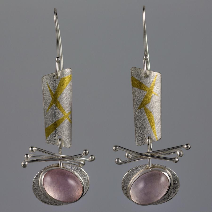 Photograph of silver and gold earrings with a pink stone.