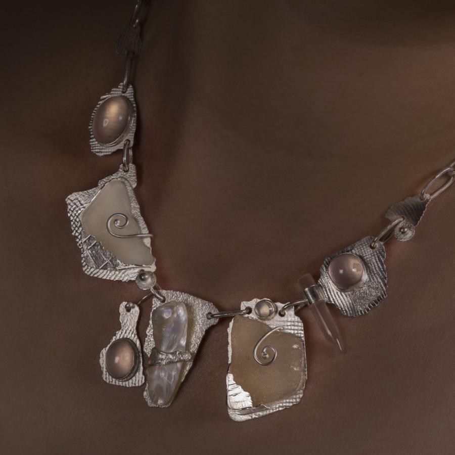 Woman wearing a handmade silver and pink stone necklace.