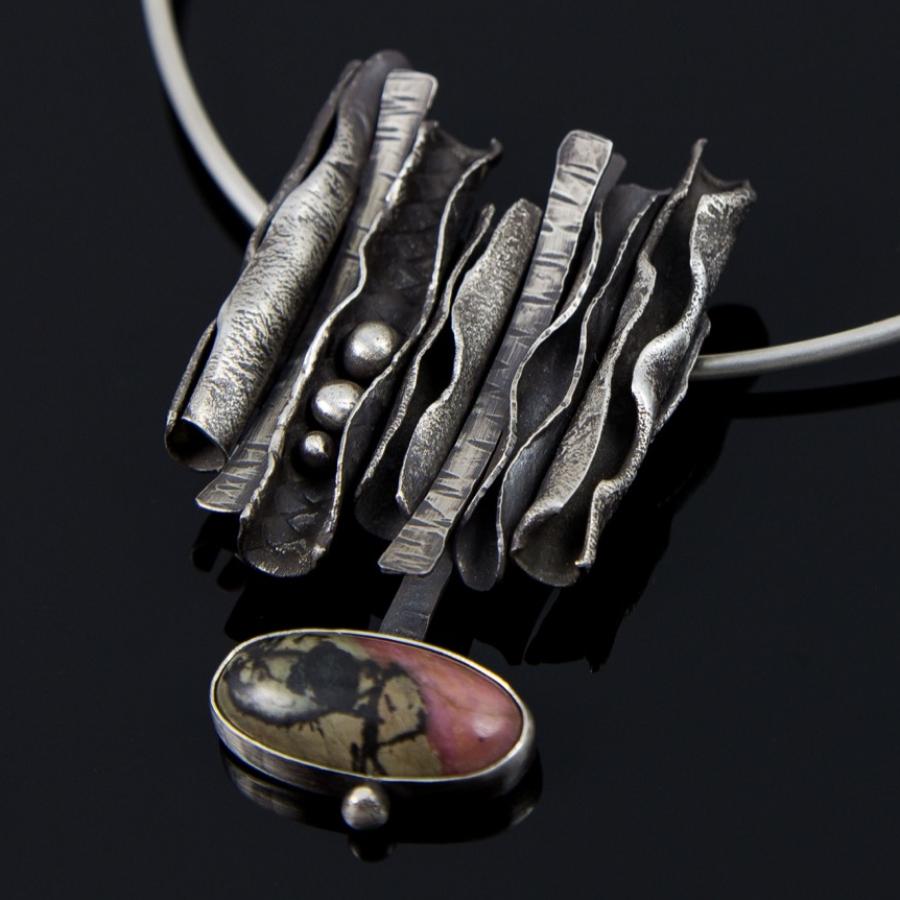 Necklace with textured silver and stone pendant.