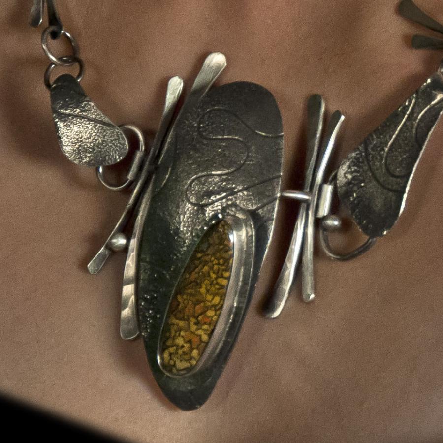 Close-up of silver statement necklace on a person.