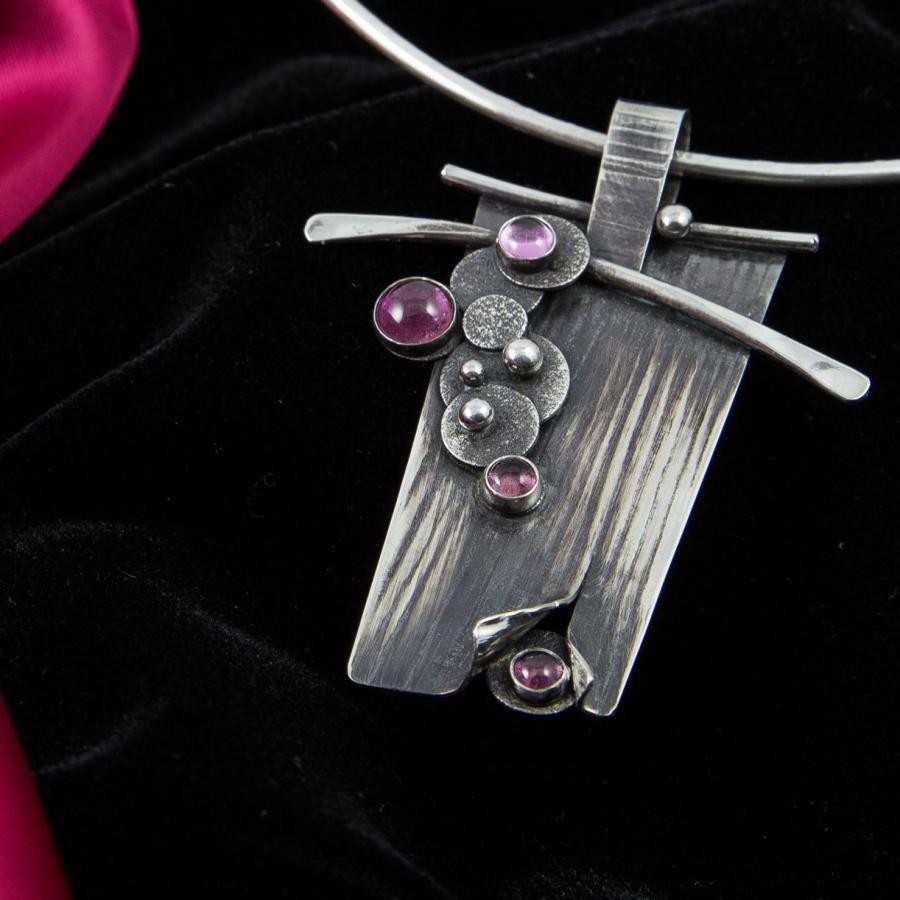 Silver pendant necklace with pink stones.