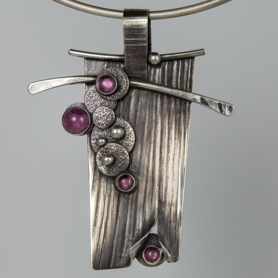 Silver necklace with purple stones, photograph.