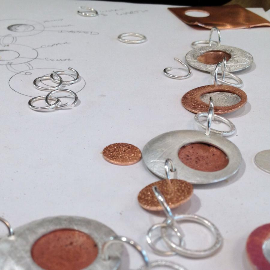 Handmade copper and silver necklace on a drawing.