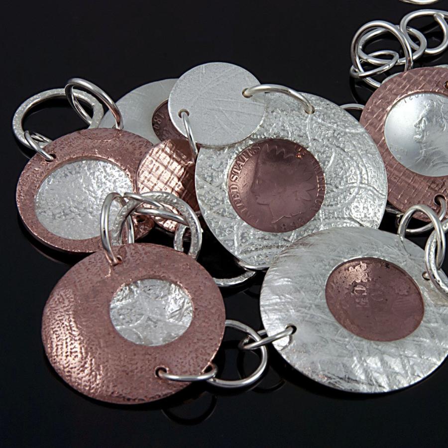 Close-up photo of a handmade metal necklace with pennies.