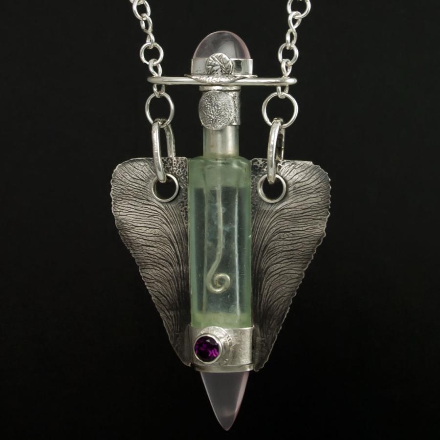 Silver necklace with glass vial pendant.