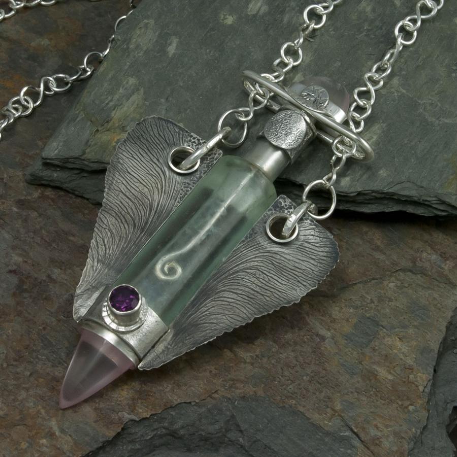 Silver necklace with glass vial pendant.