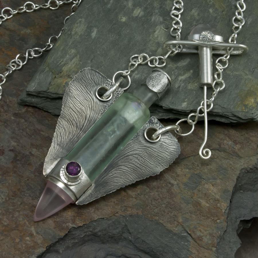 Silver necklace with glass vial pendant.