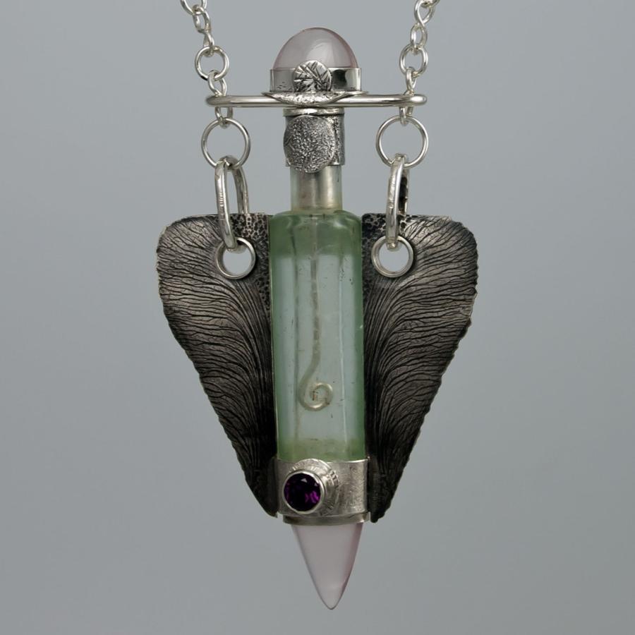 Silver necklace with glass vial pendant.