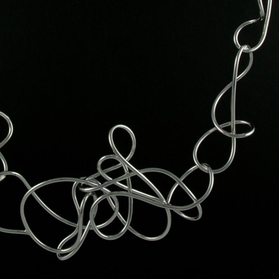 Silver necklace on black background.