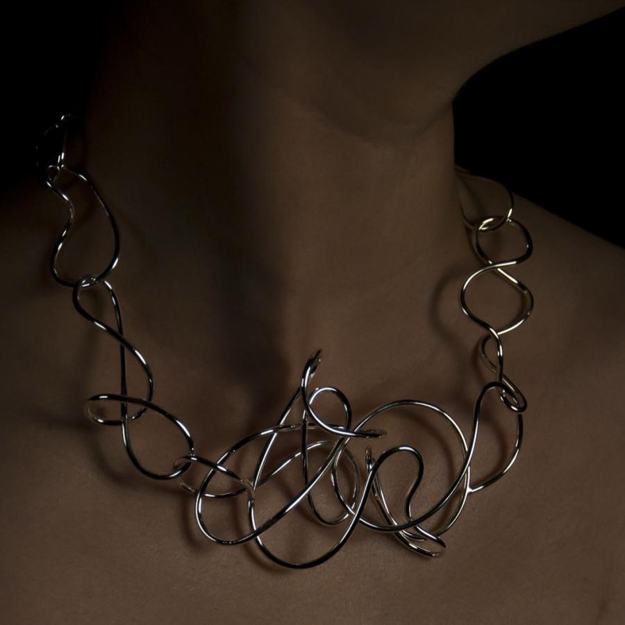Woman wearing a silver statement necklace, photograph.