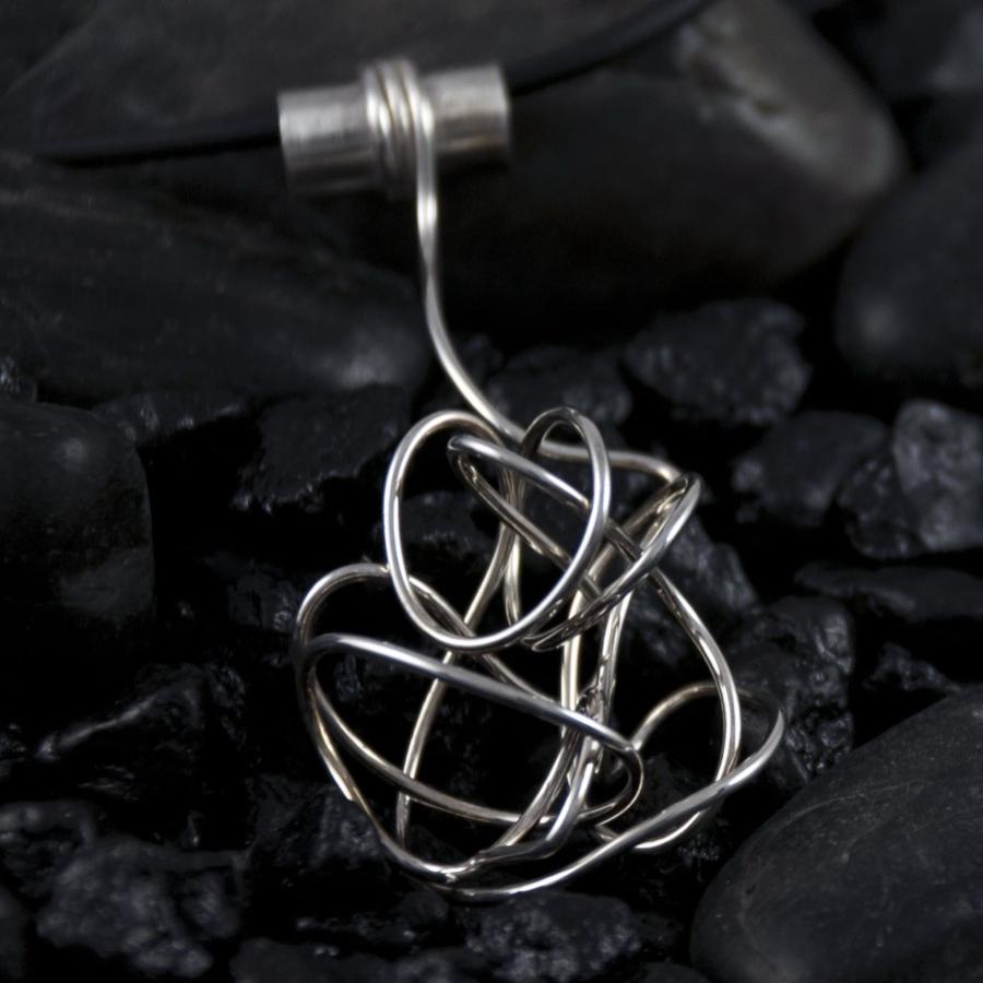 Tangled silver wire pendant on a black cord with black rocks.
