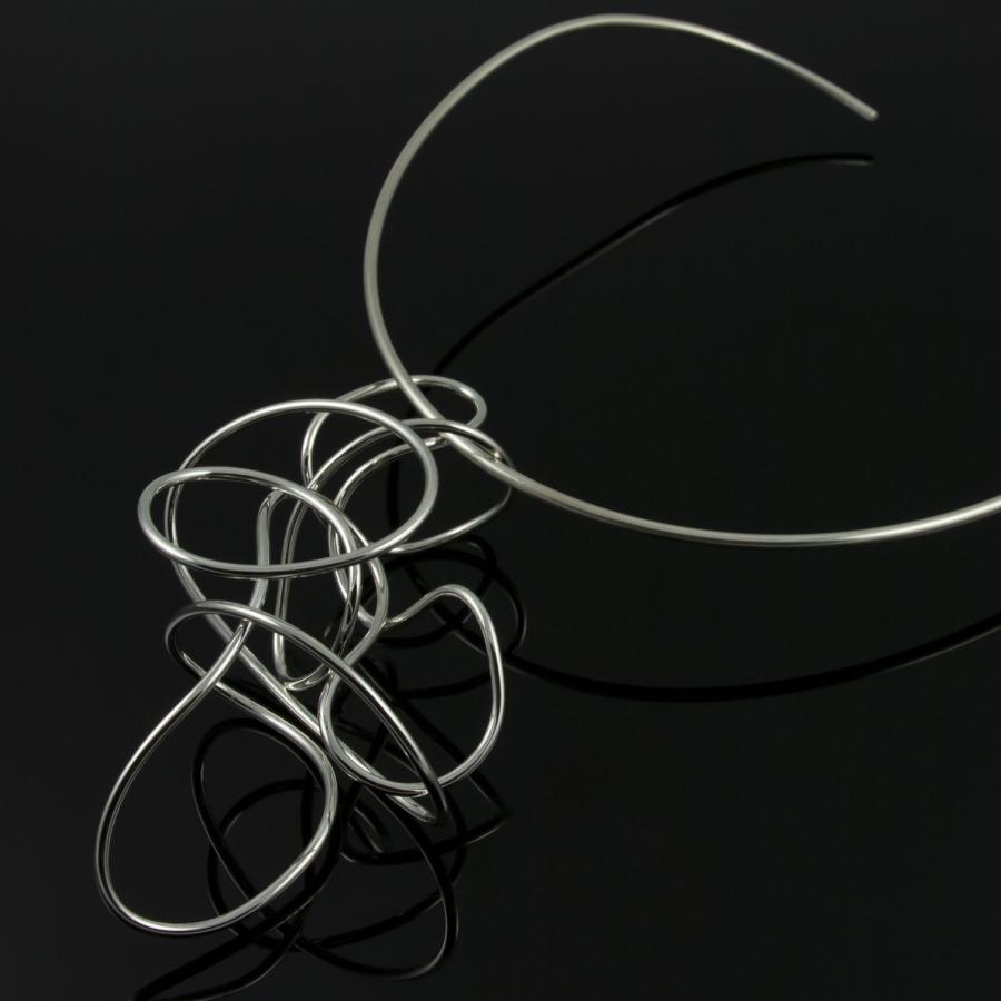 Silver necklace with flowing, looping design.