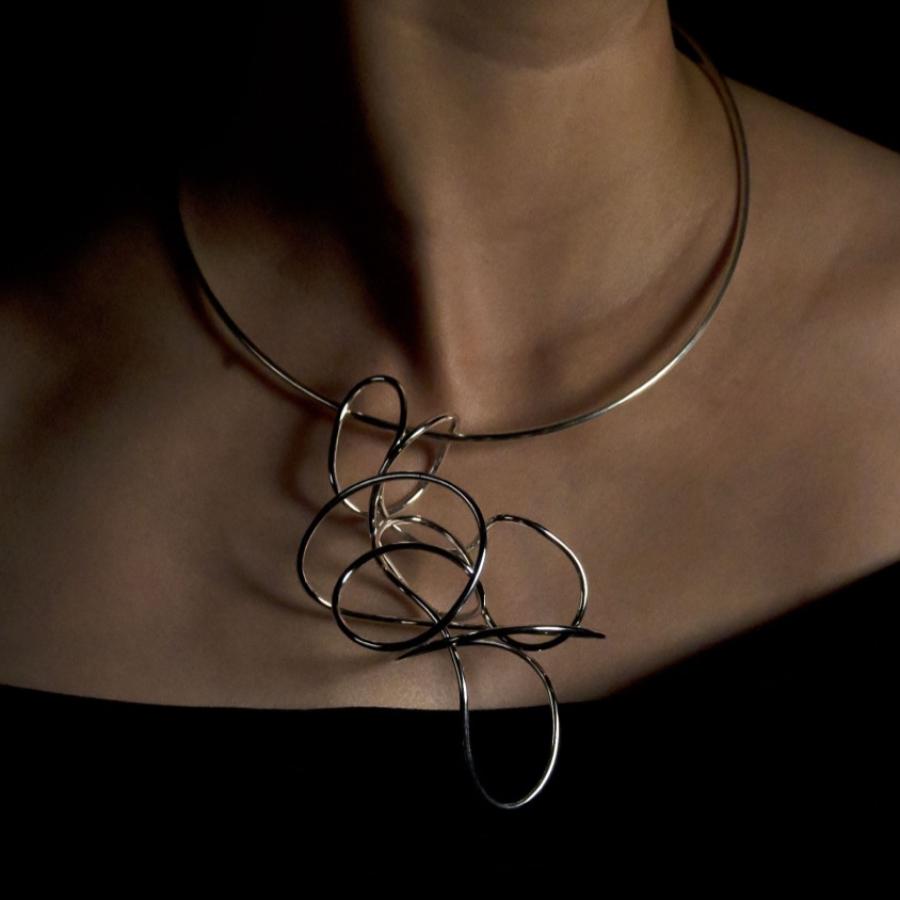 Woman wearing silver necklace, photograph.