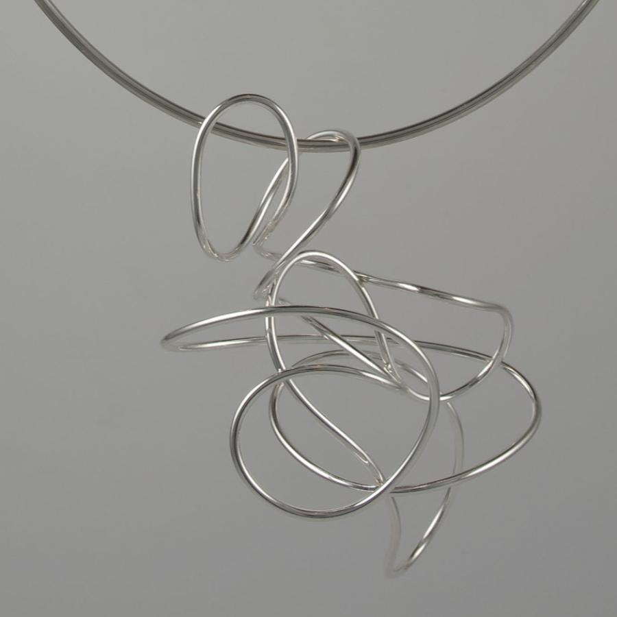 Silver necklace with flowing, looping design.