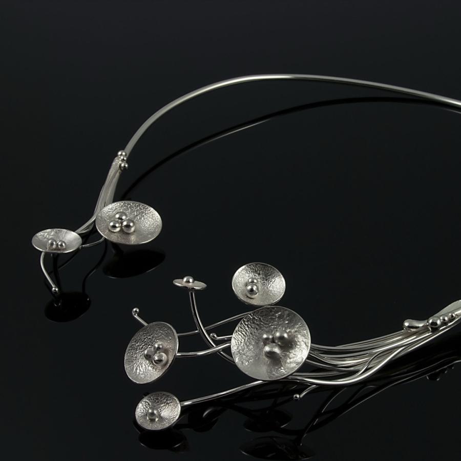 Silver wire collar necklace with circular and seed pod-like accents.