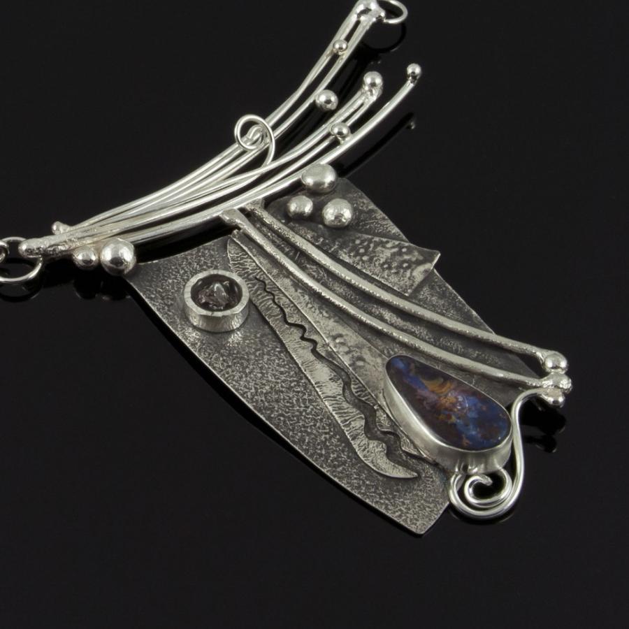 Silver crafted necklace with decorative pendant.
