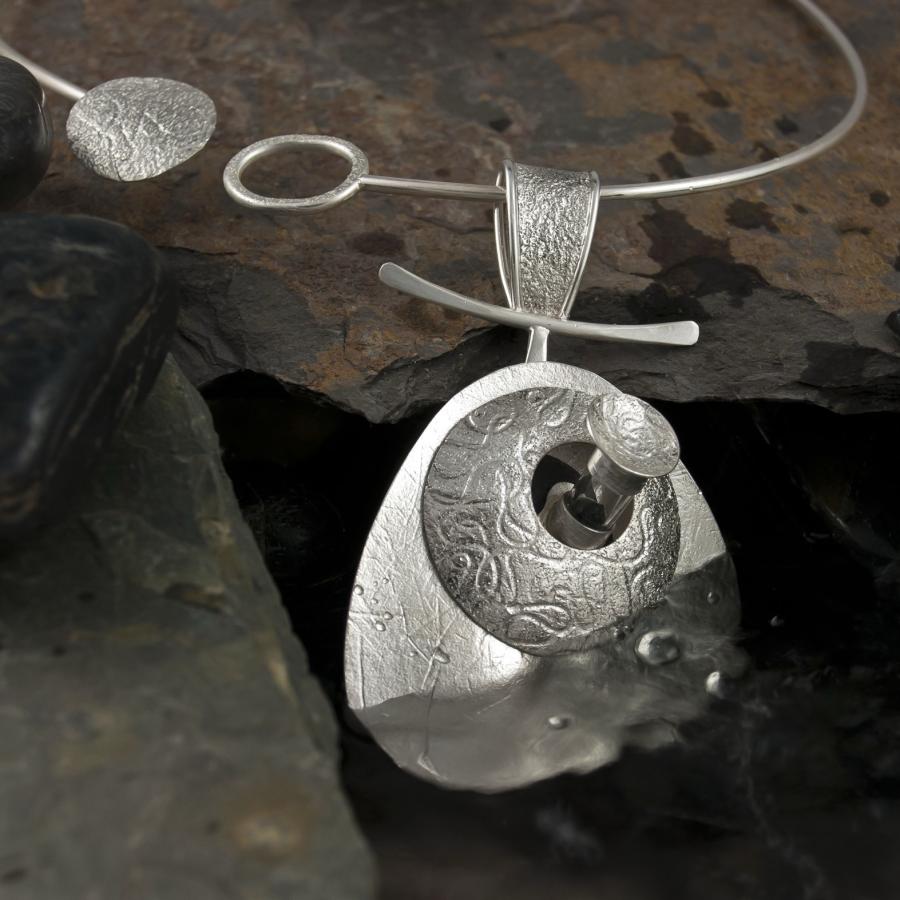 Silver necklace with unique pendant, close-up.
