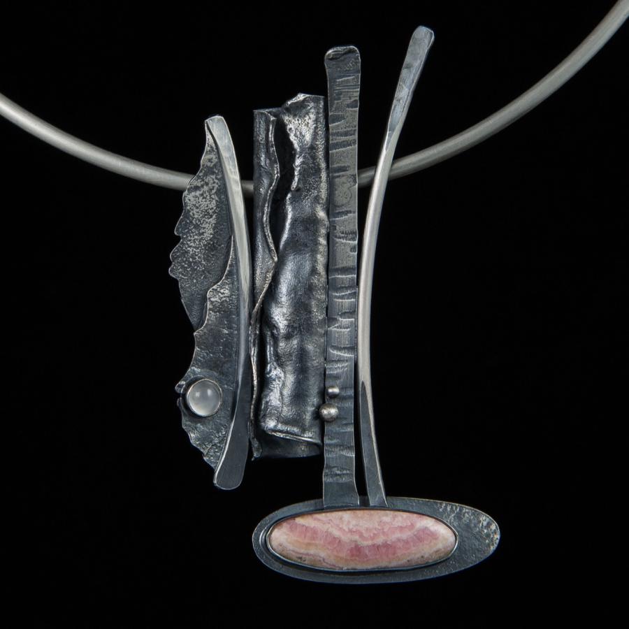 Silver necklace with modern, abstract pendant.
