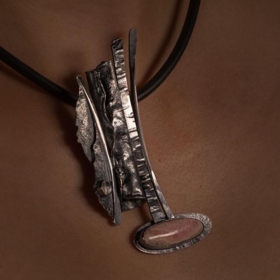 Woman's chest with abstract pendant necklace.