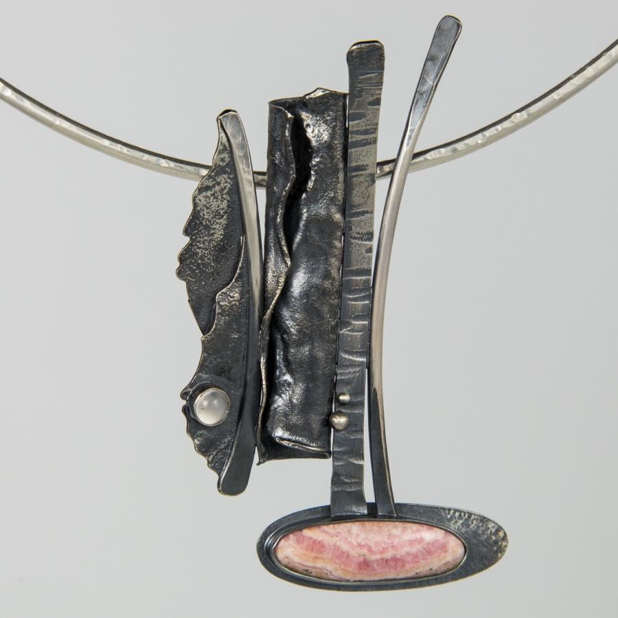Silver abstract necklace, studio photograph.
