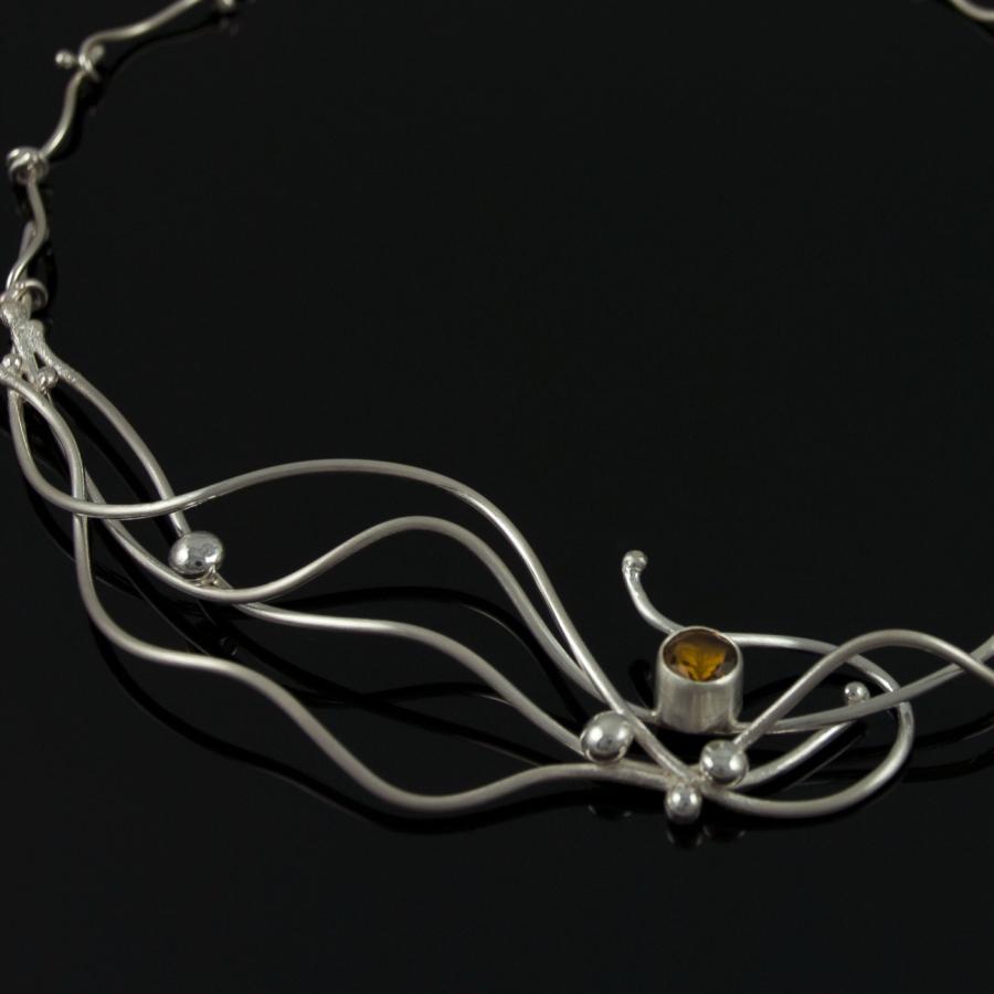 Silver necklace with amber colored gem.