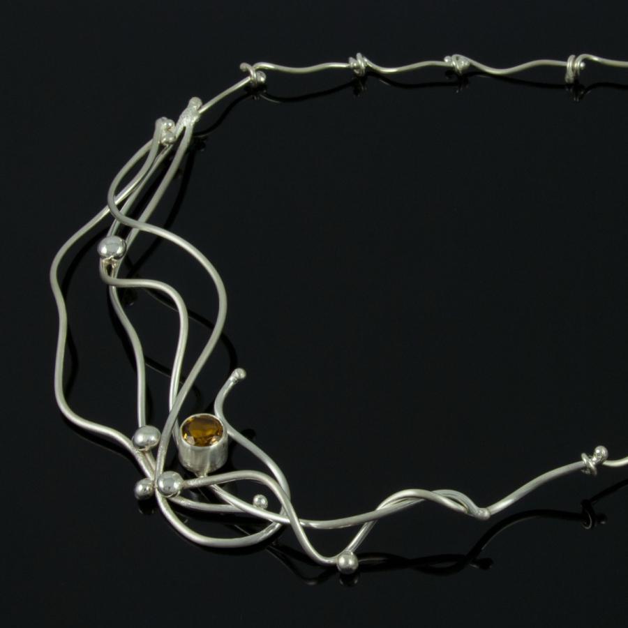 Silver necklace with amber colored gem.