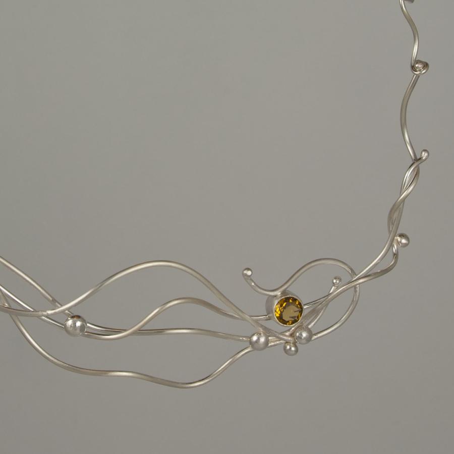 Silver necklace with amber colored gem.