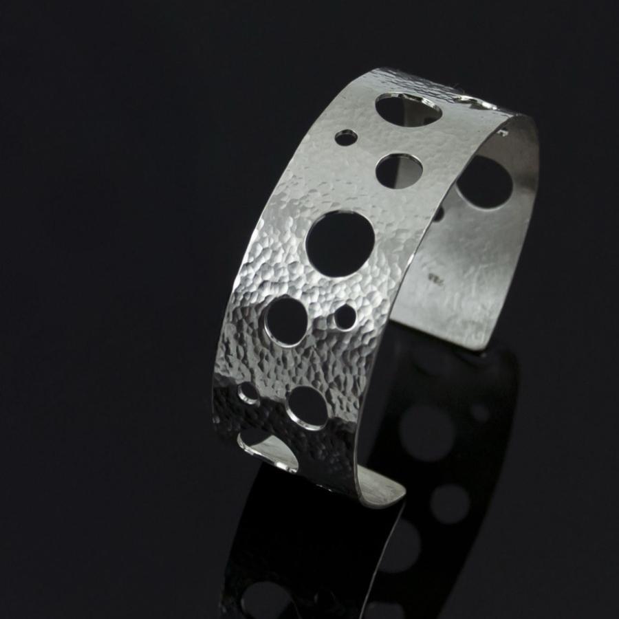 Silver hammered bracelet with holes.