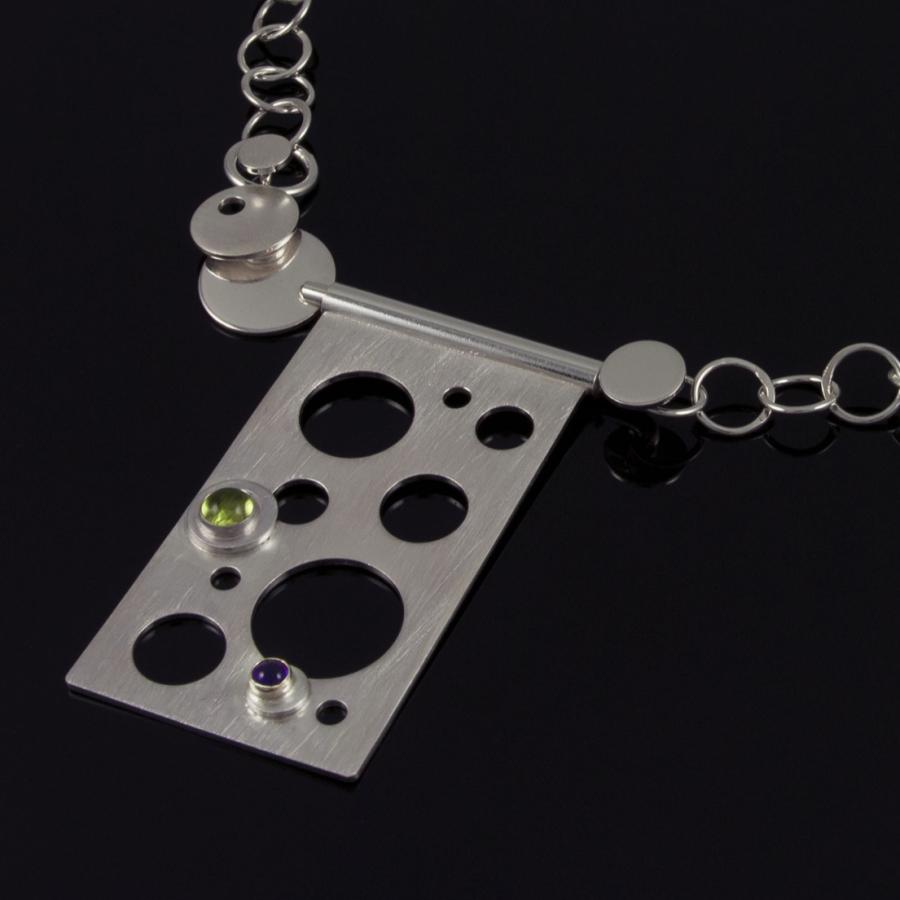 Silver chain necklace with geometric shapes, photograph.