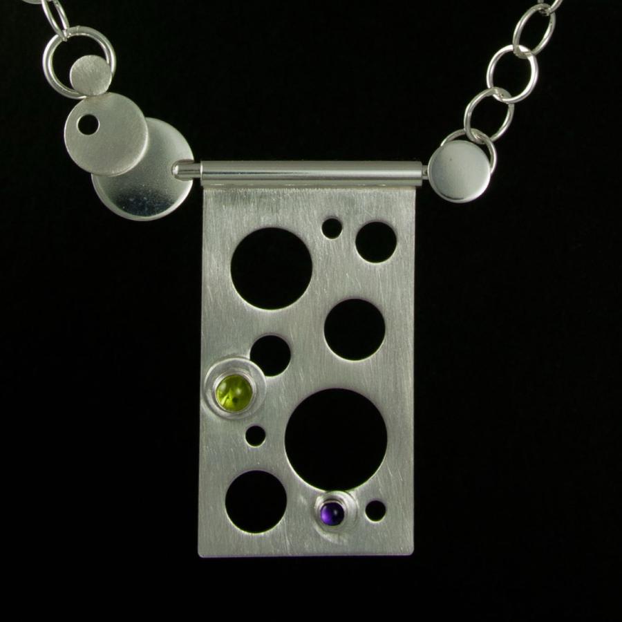 Silver necklace with geometric shapes, colorful gemstones.