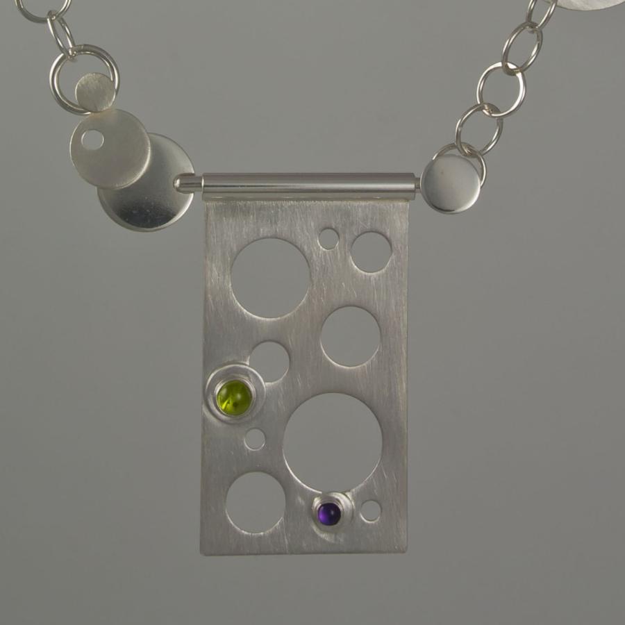 Silver necklace with geometric pendant and colored gems.