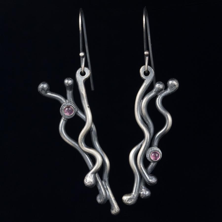Silver earrings with pink stones, photograph.