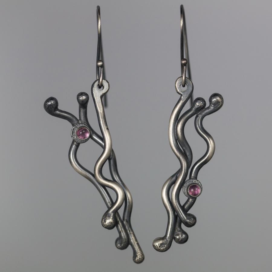 Silver earrings with pink stones, photograph.